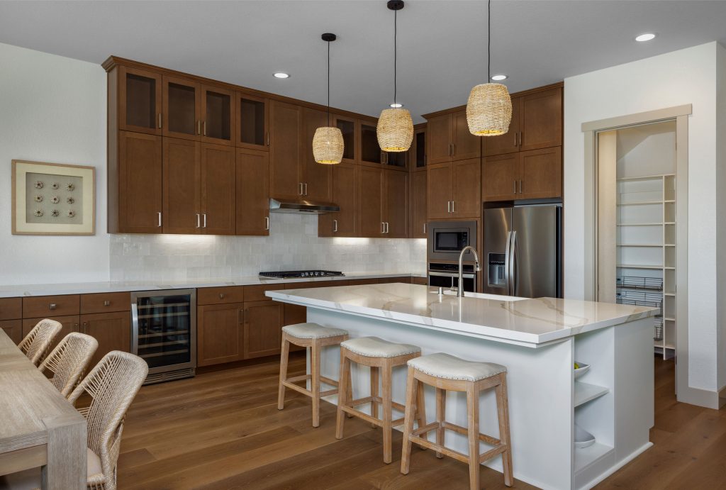 residence 2 kitchen at skye II at river islands with white island and wooden cabinetry